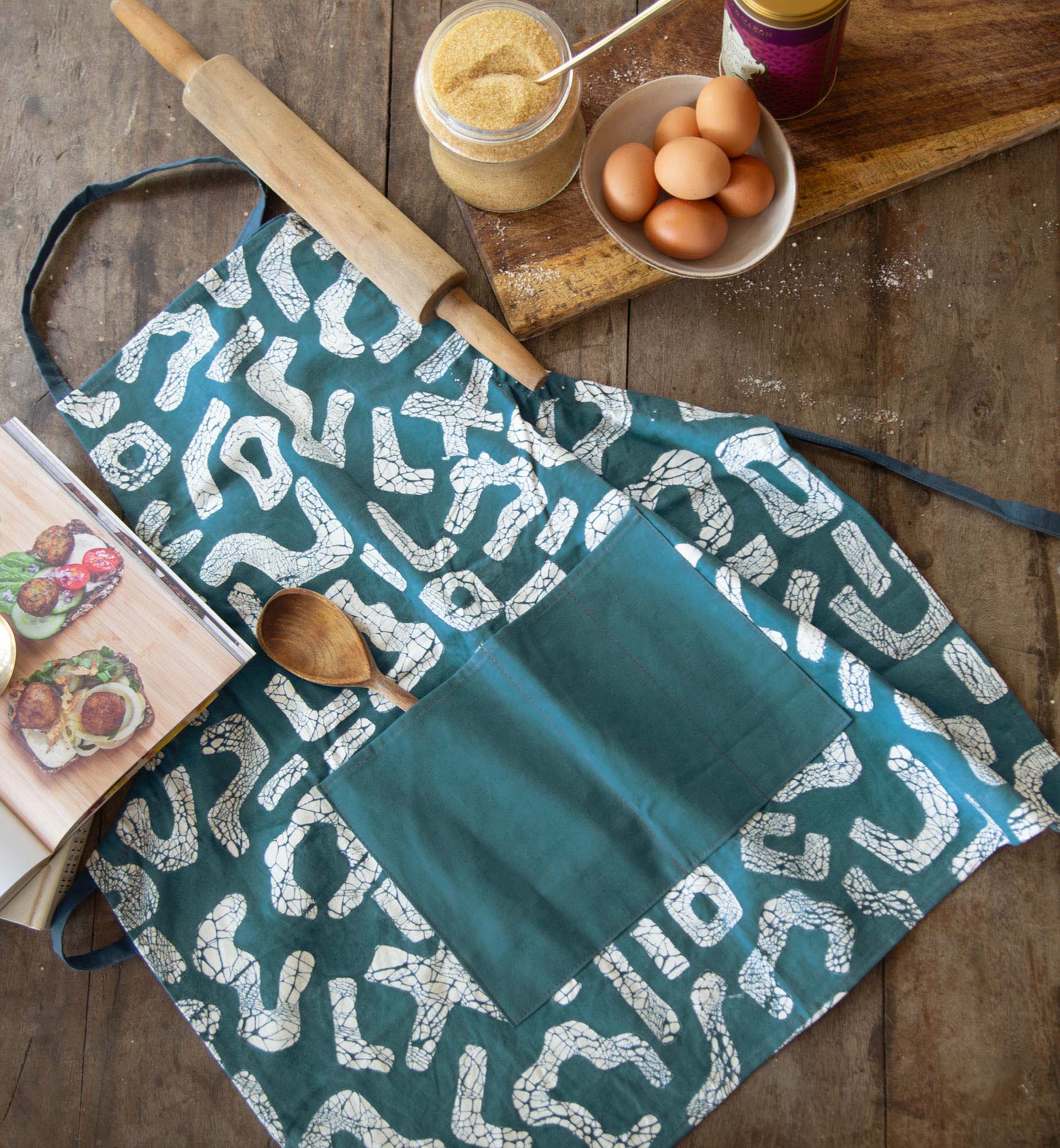 Hand-made teal apron, made from 100% cotton, adorned with a squiggle pattern.