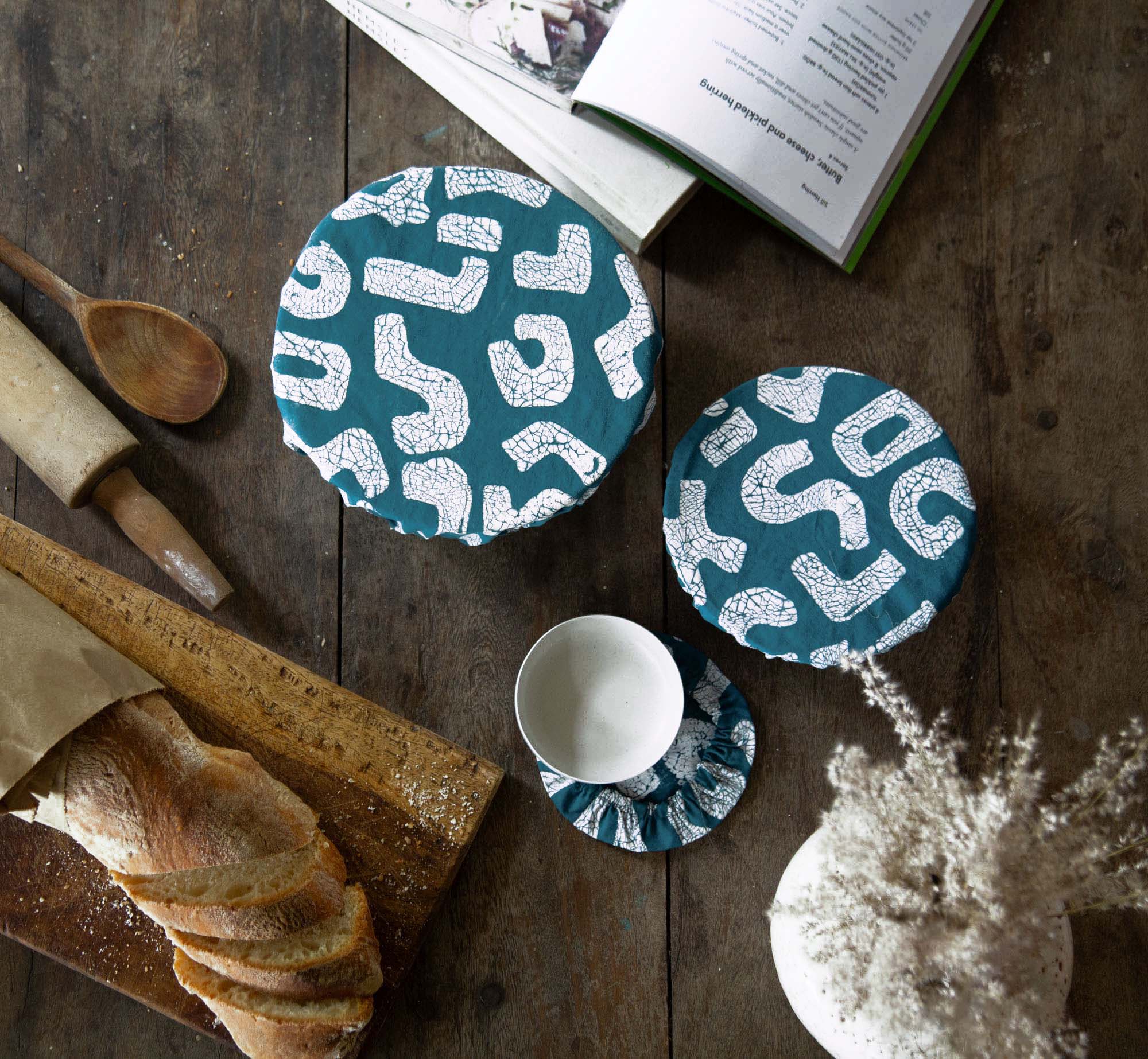 African made teal bowl covers adorned in a squiggle pattern, with sustainably sourced elastic and fabric.