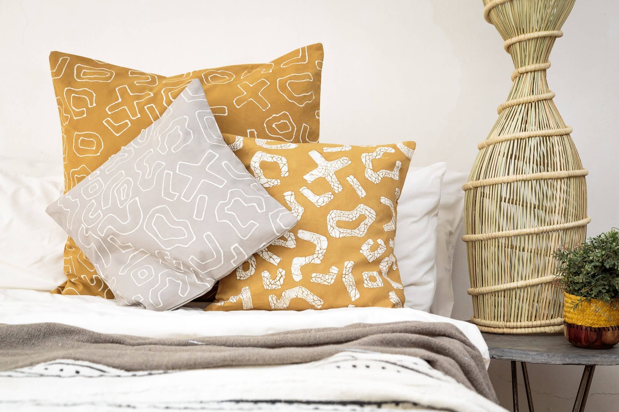 Eco-friendly pillow cover in bright yellow with a bold graphic batik pattern, perfect for lively/sustainable living spaces.