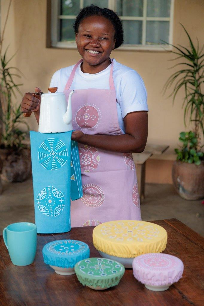 African made, bright yellow bowl covers adorned with strong elastic and detailed circular patterns.